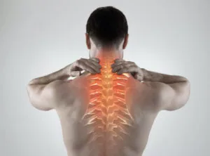 Man touching upper back with hands, glowing orange overlay showing spine and nerve pathways